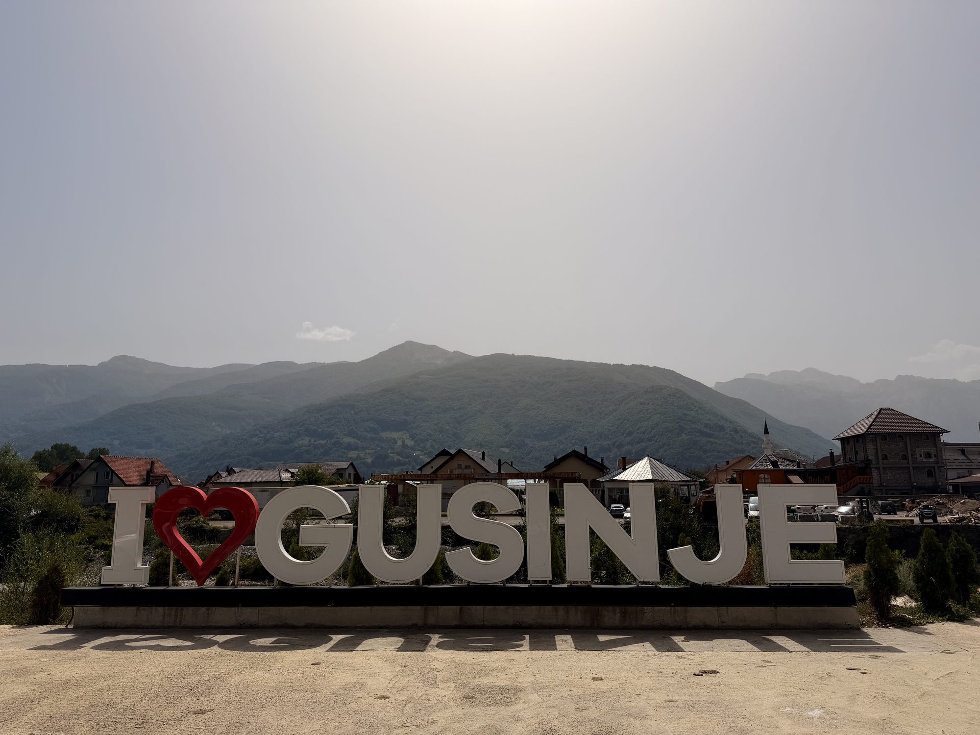 I love Gusinje sign in the centre of Gusinje, Montenegro, with the Prokletije mountains behind